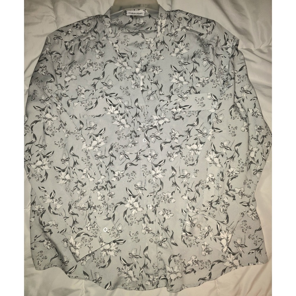 This Calvin Klein blouse features a light gray fabric adorned with a black...